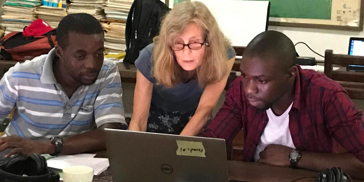 three people looking at a laptop screen